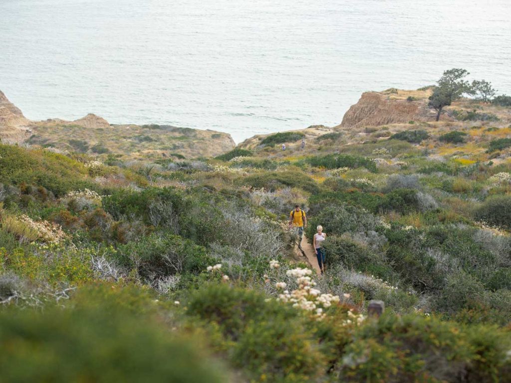 Couple hiking near beach by Del Mar, CA