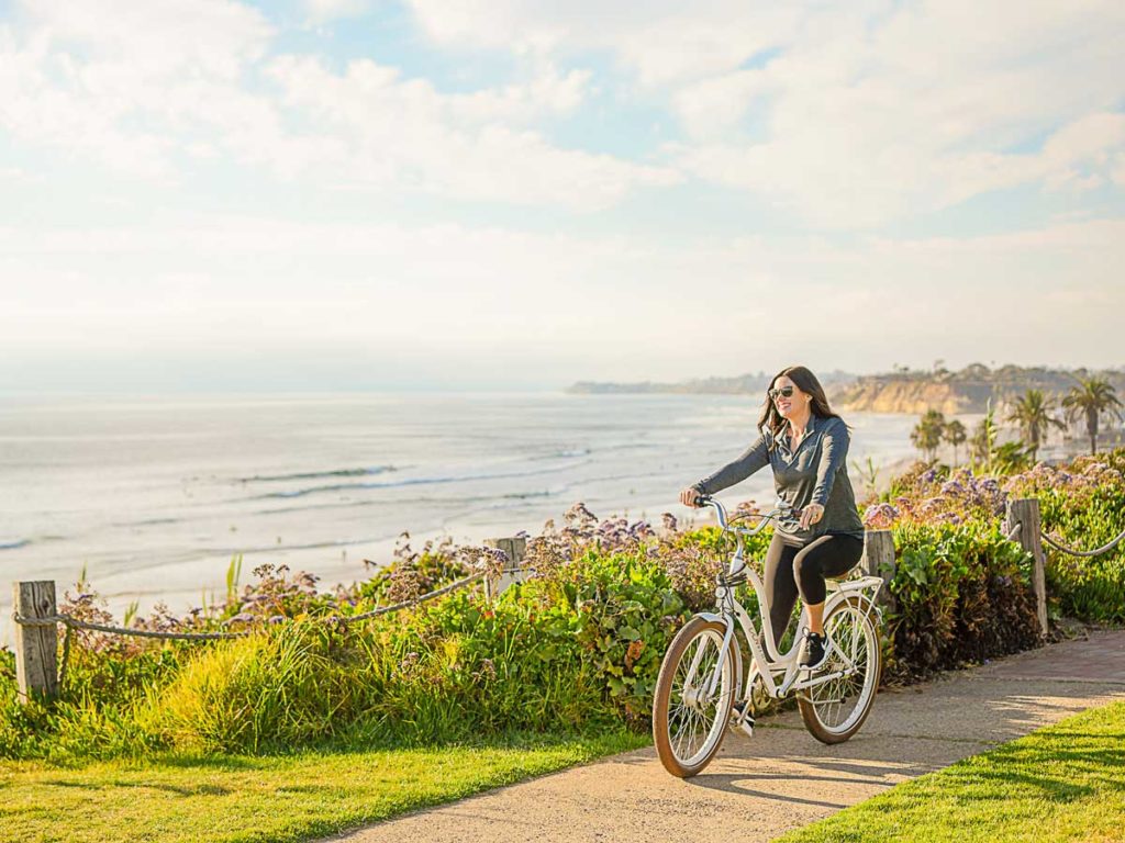 Girl biking along the coast.