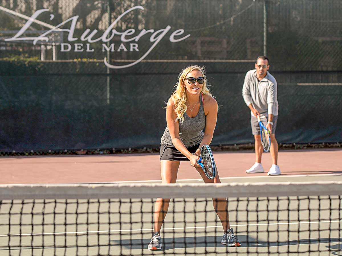 Couple playing tennis at LAuberge.