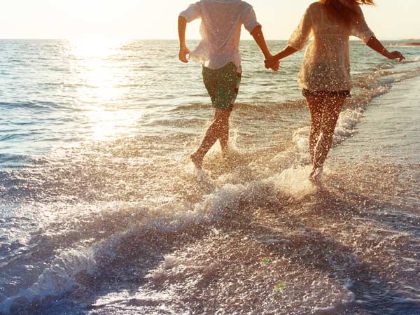 Couple Running On The Beach.