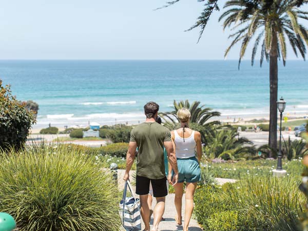 Couple Walking Down To The Beach.