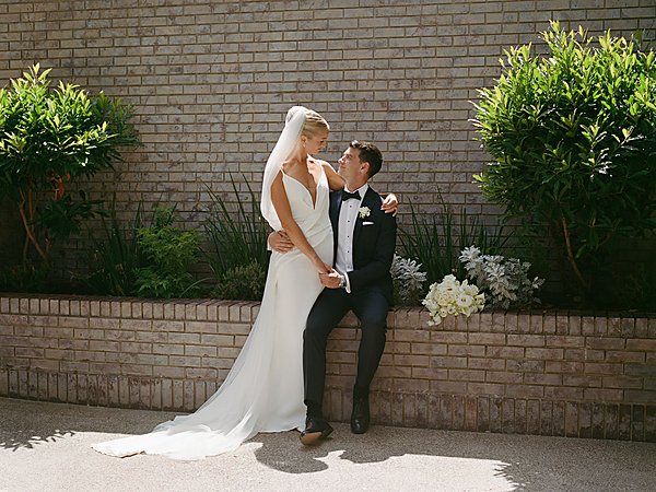 Bride and groom embracing in the garden courtyard at L'Auberge Del Mar, a luxury wedding venue in Del Mar, California