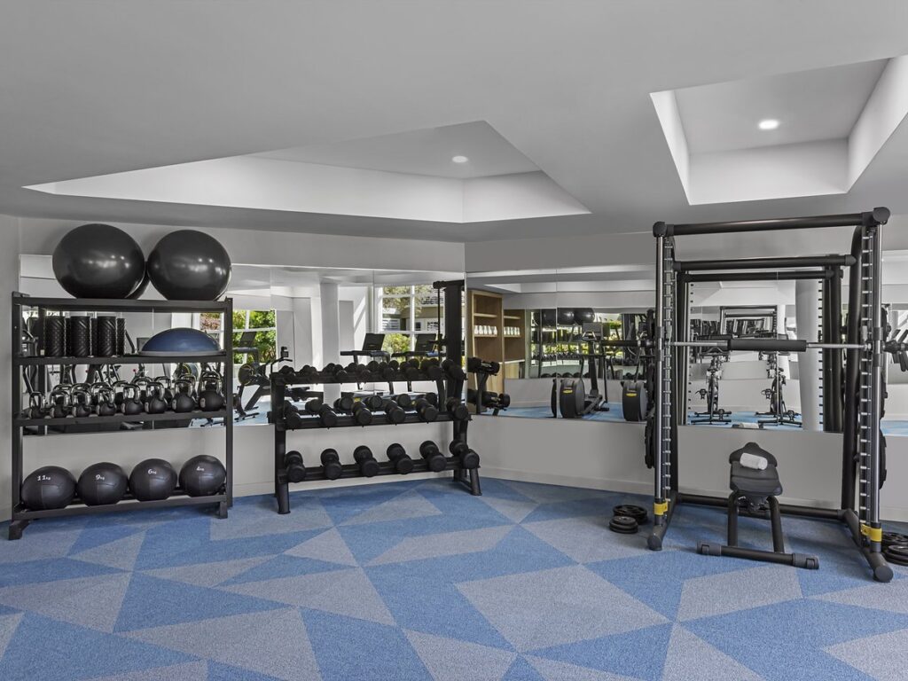 Bright fitness center at L'Auberge Del Mar with dumbbells, kettlebells, medicine balls and a strength training rack at the luxury resort in Del Mar, California